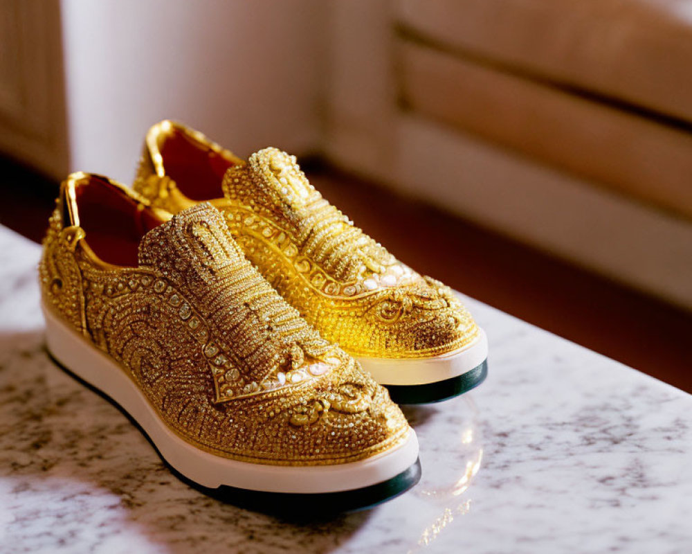 Golden Bejeweled Slip-On Sneakers on Marble Surface
