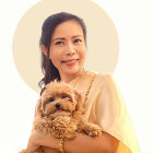 Serene woman holding small dog in warm light