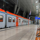 Futuristic orange and white train at modern, brightly-lit platform