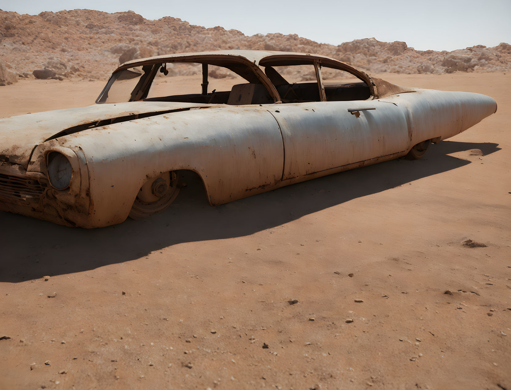 Abandoned car without wheels in desert landscape