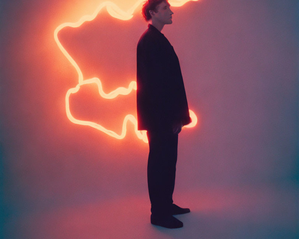 Profile of a man with neon light abstract shape on gradated background