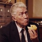 Silver-Haired Man Contemplating Donut in Classic Room