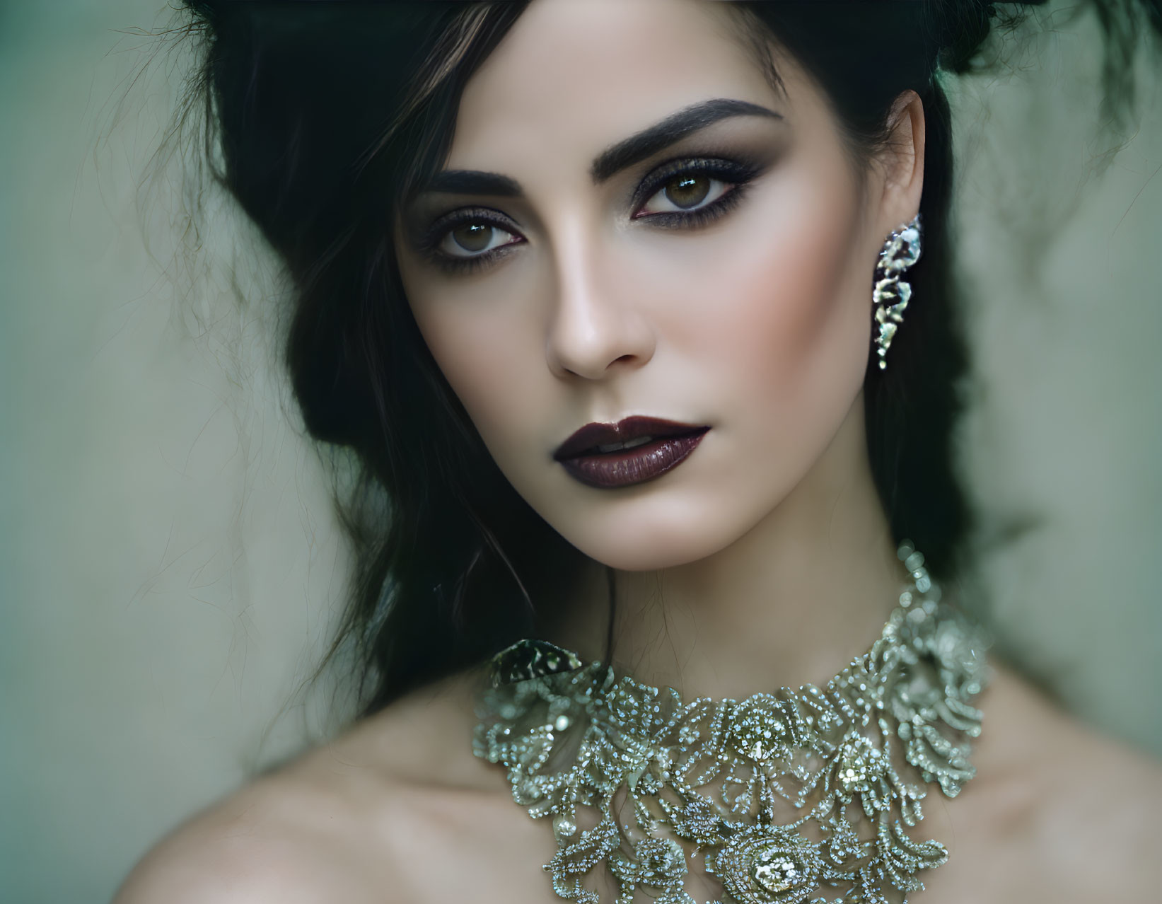 Person with Smoky Eye Makeup, Dark Lipstick, and Elaborate Silver Jewelry