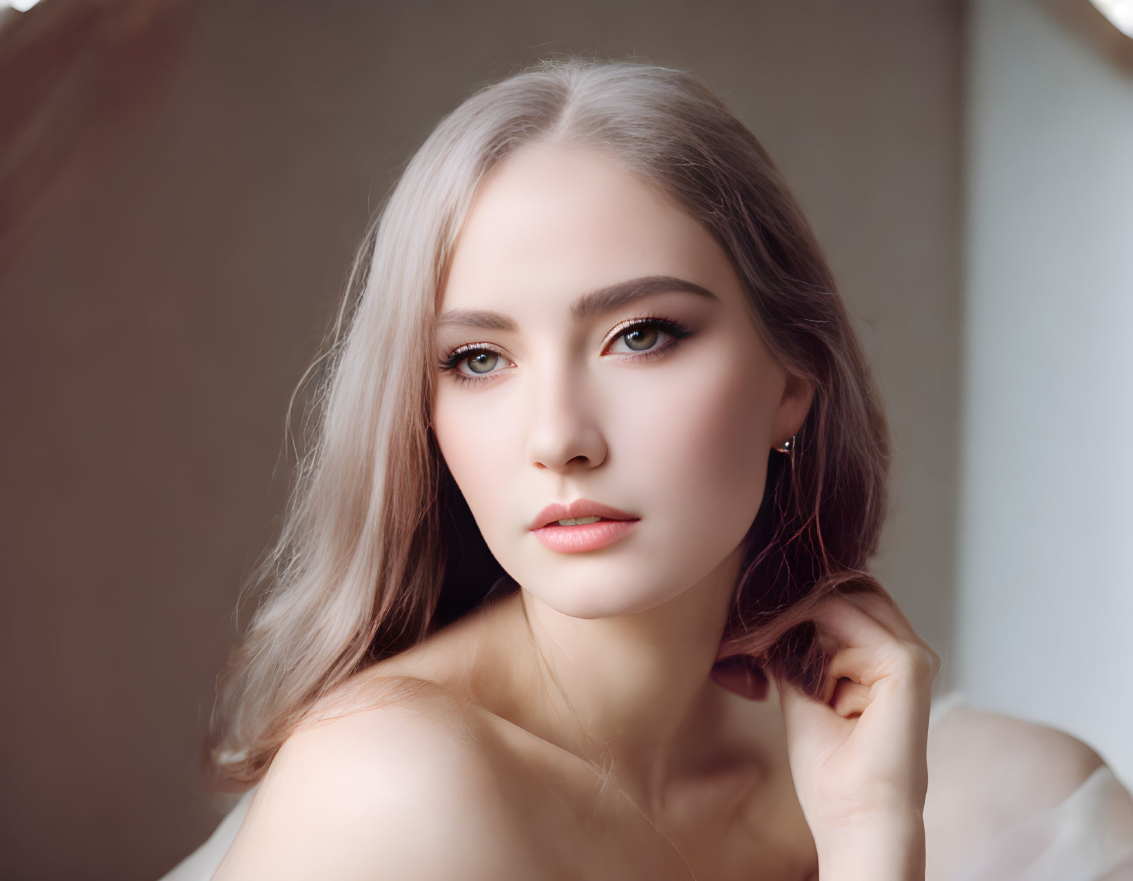 Portrait of Woman with Silver Blonde Hair and Striking Makeup on Neutral Backdrop