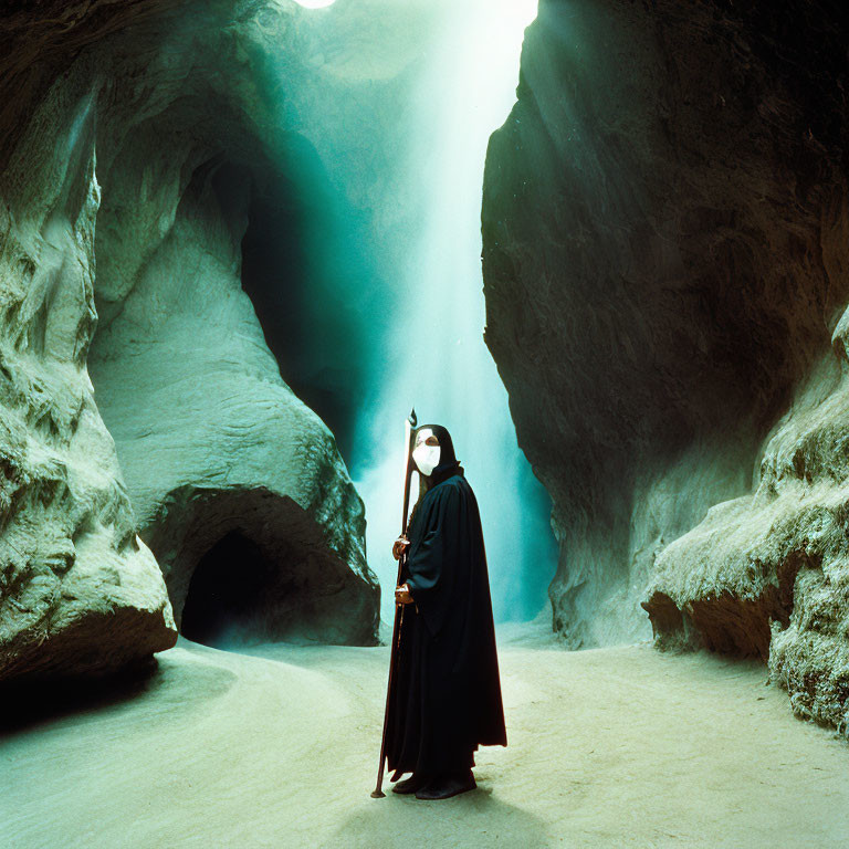 Mysterious figure in black cloak and mask in cave with light shaft
