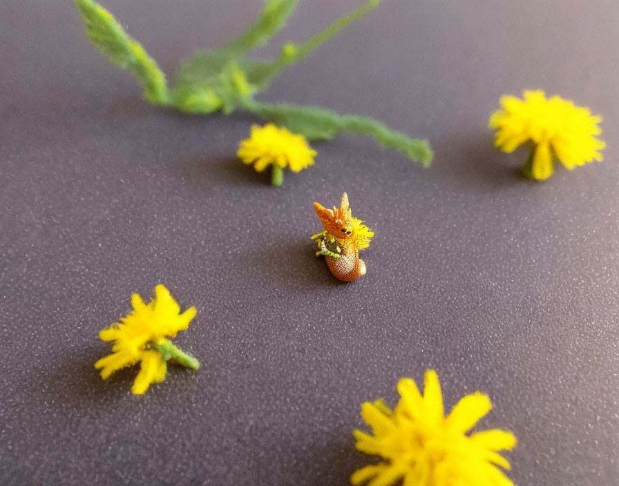 Miniature fox figurine amidst yellow dandelion flowers on dark background