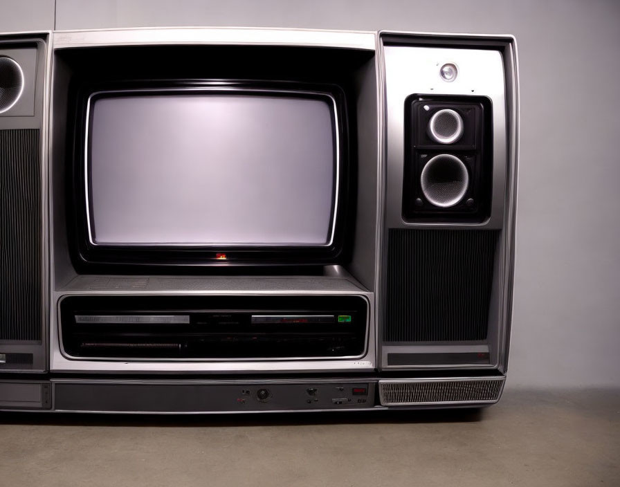 Vintage TV with large screen, side speakers, VCR, and front panel buttons on plain background