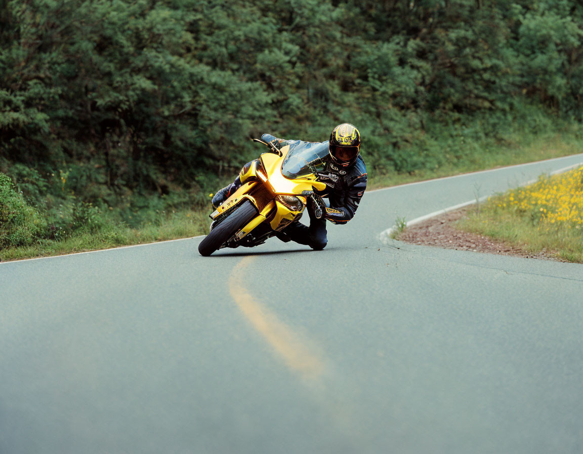 Motorcyclist in Black and Yellow Suit Riding Sharp Turn on Rural Road