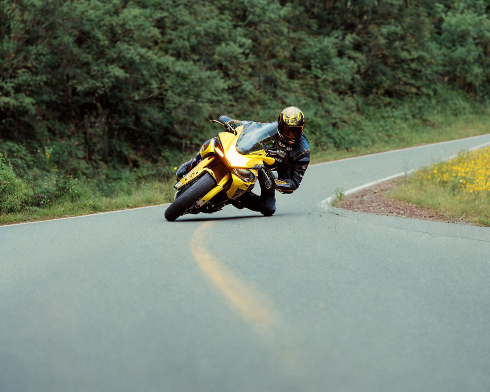 Motorcyclist in Black and Yellow Suit Riding Sharp Turn on Rural Road