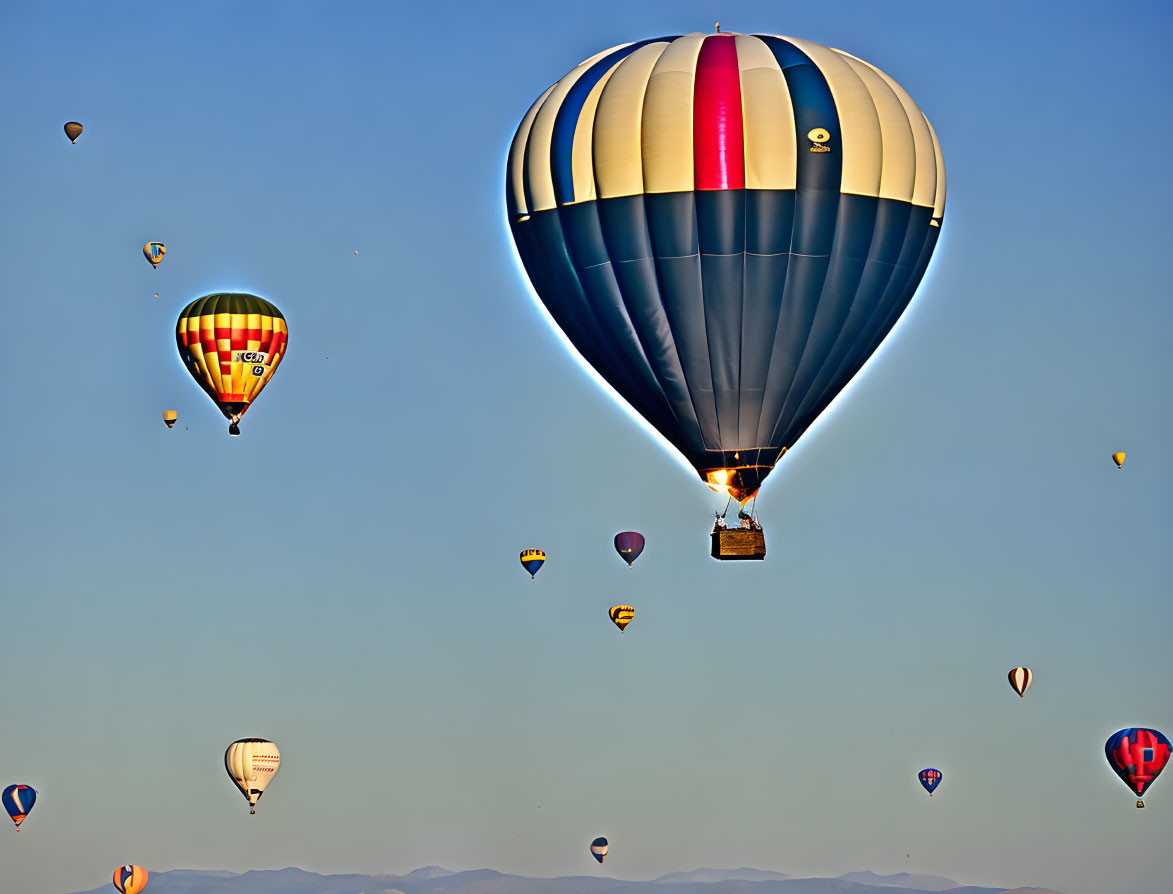 Colorful hot air balloons in clear blue sky at dawn or dusk