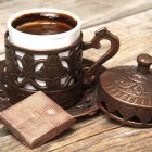 Chocolate-themed coffee cup with heart design & dessert on wooden table