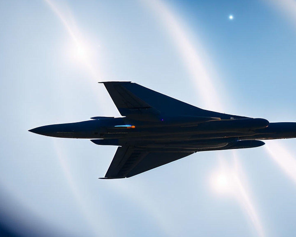 Military jet with afterburners in blue sky with sun halo.