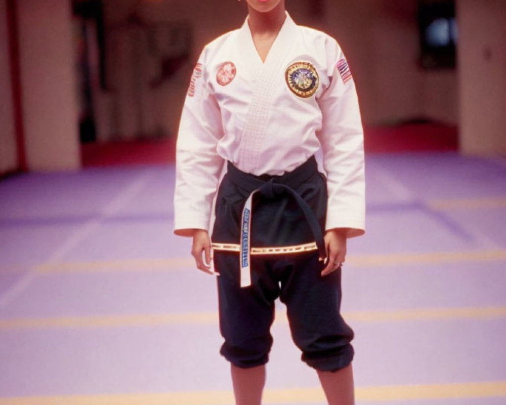 Person in white karate gi with black and red belt on red dojo mat