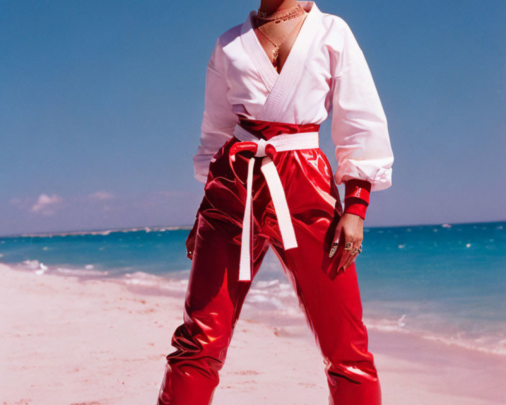 Person on Beach in White Top and Red Satin Pants with Gold Jewelry