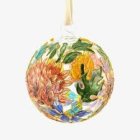 Intricate gold, green, and orange bauble with leaf and paisley designs on white background