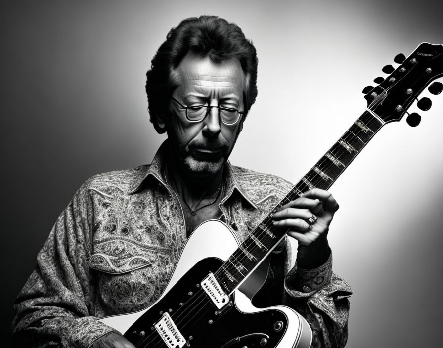 Monochrome portrait of man with glasses and beard playing electric guitar