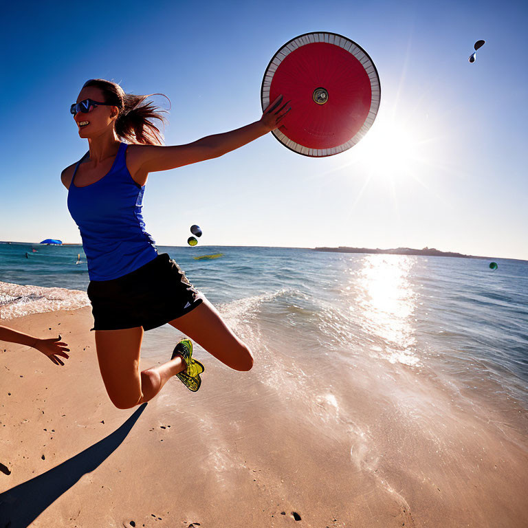 Woman in sportswear playing frisbee on sunny beach