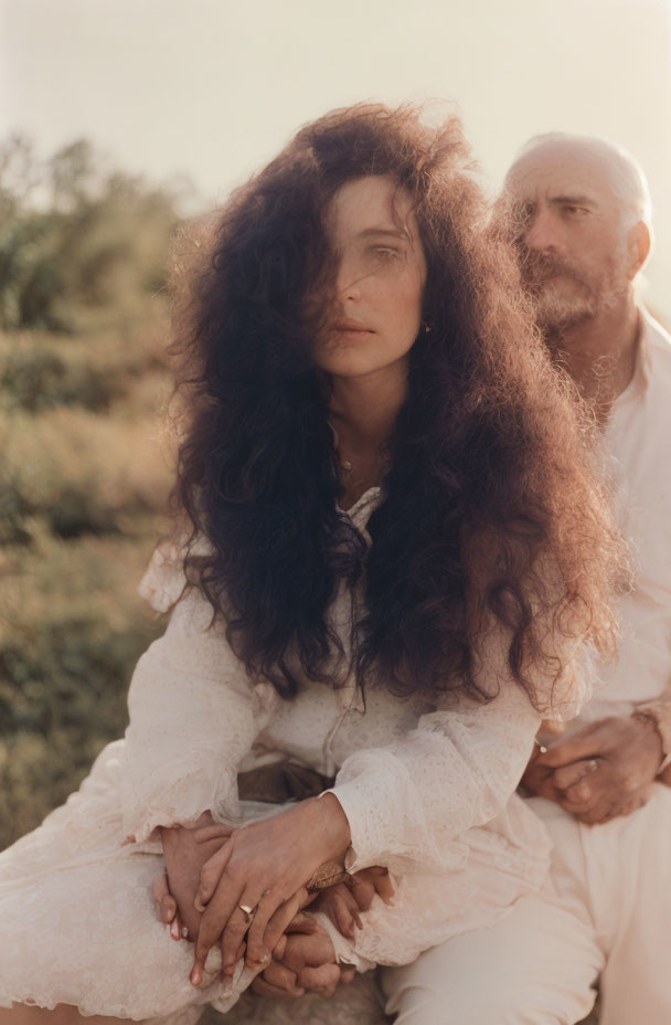 Vintage-dressed woman with curly hair and man in soft light setting