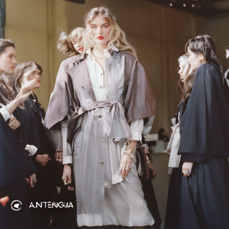 Fashion show featuring models in trendy grey trench coats and white dresses.