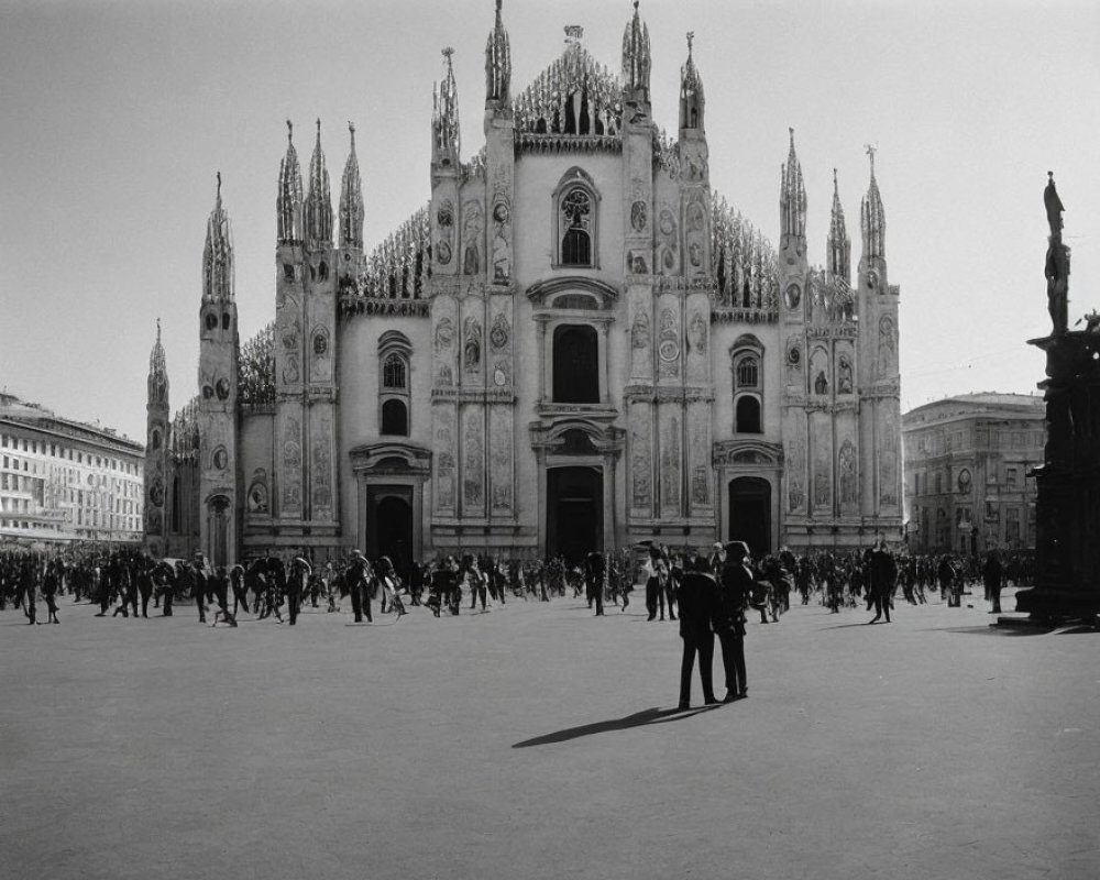 Crowded square with Milan Cathedral facade in monochrome.