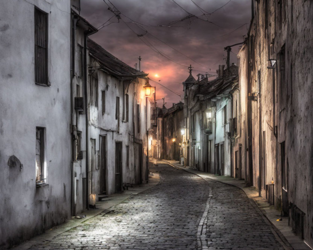Cobblestone street at dusk with old white buildings under moody sky
