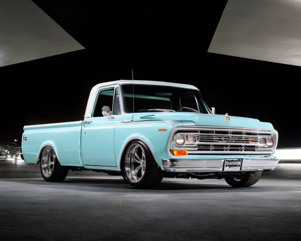 Vintage Turquoise Pickup Truck with Chrome Wheels Under Bridge at Night