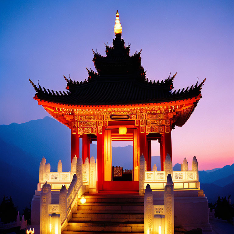 Traditional Chinese Pagoda Illuminated at Dusk with Mountainous Backdrop