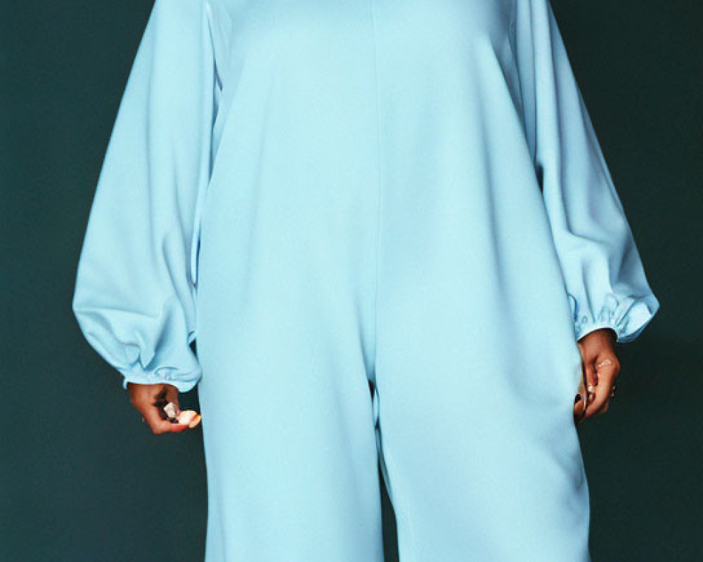 Stylish woman in light blue jumpsuit with bishop sleeves