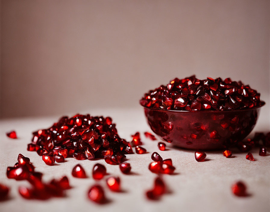 Bowl of Pomegranate Seeds on Table in Warm Red Hue