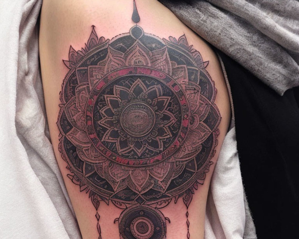 Detailed Black Mandala Tattoo on Upper Arm with Intricate Patterns and Dangling Designs