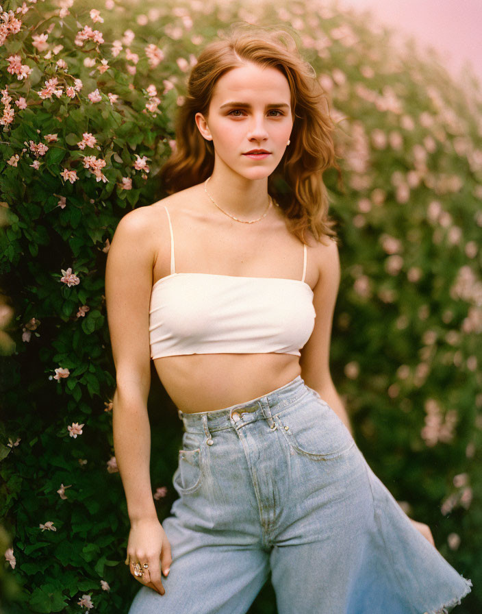 Woman in White Crop Top and Jeans Standing by Flowering Bushes