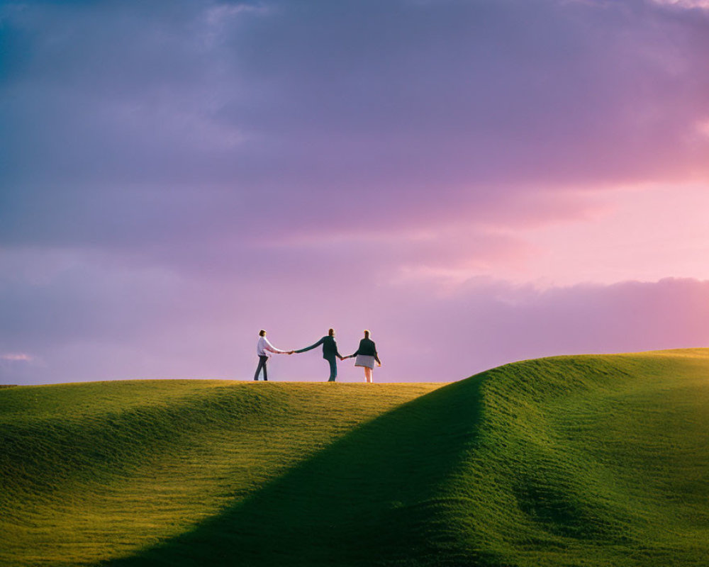 Couple holding hands on hill under vibrant dusk sky