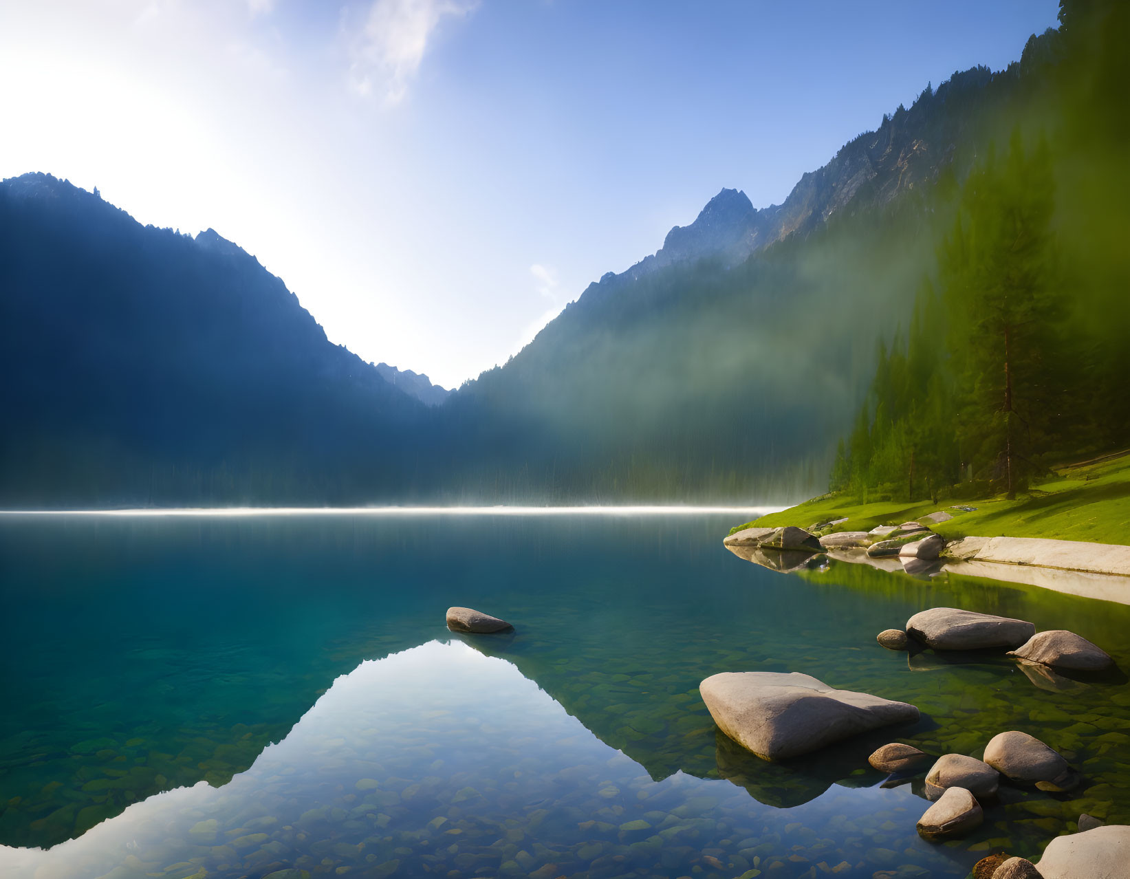 Tranquil mountain lake with forested slopes and rocky shores