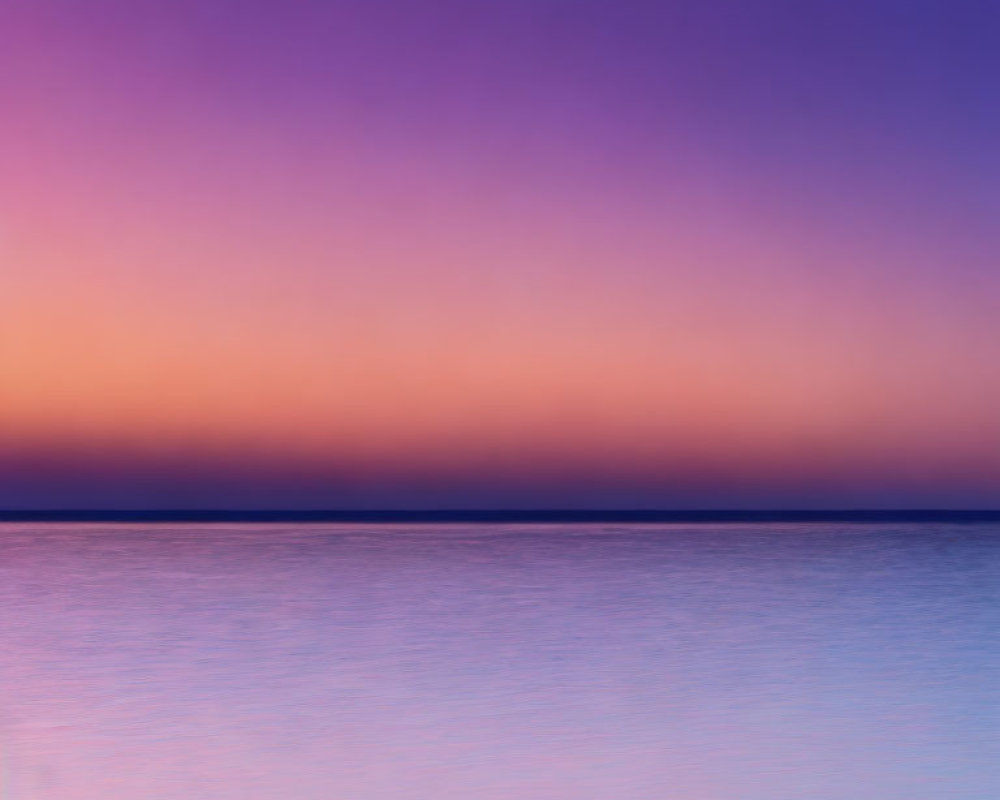 Vibrant sunset colors over calm ocean: purple, pink, blue
