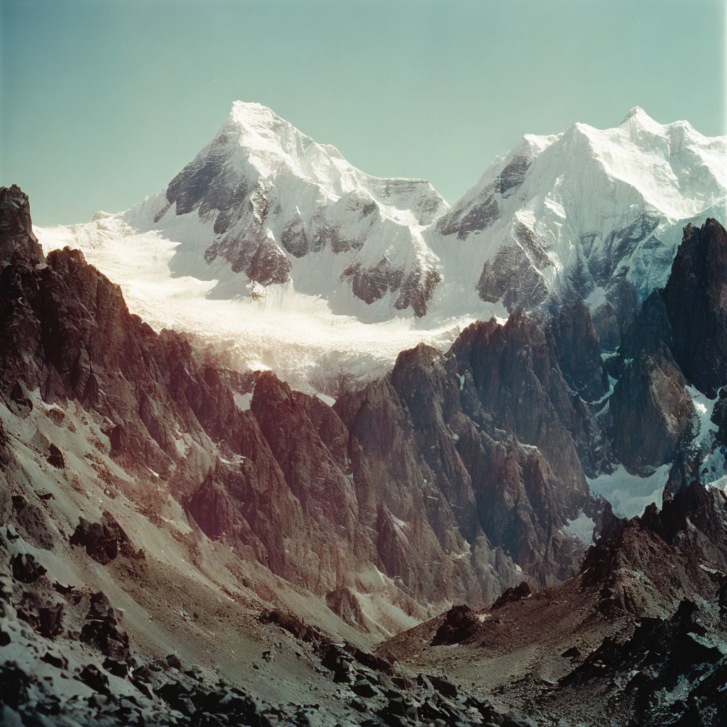 Snow-capped peak and glacier in mountain range under blue sky