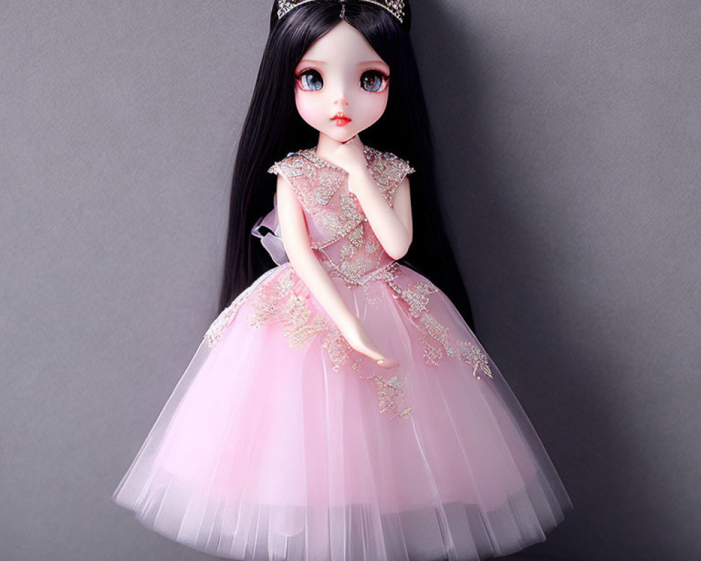 Black-haired doll in pink princess dress with tiara and golden details