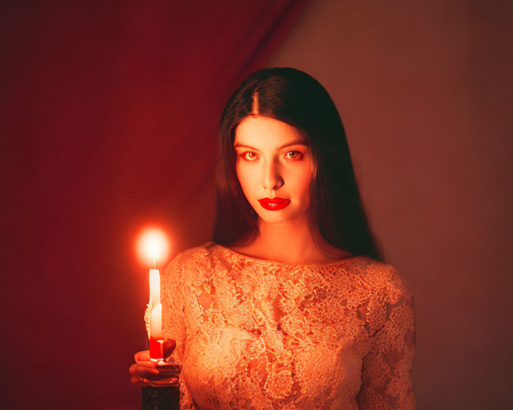 Woman in lace dress holding candle in dimly lit red room