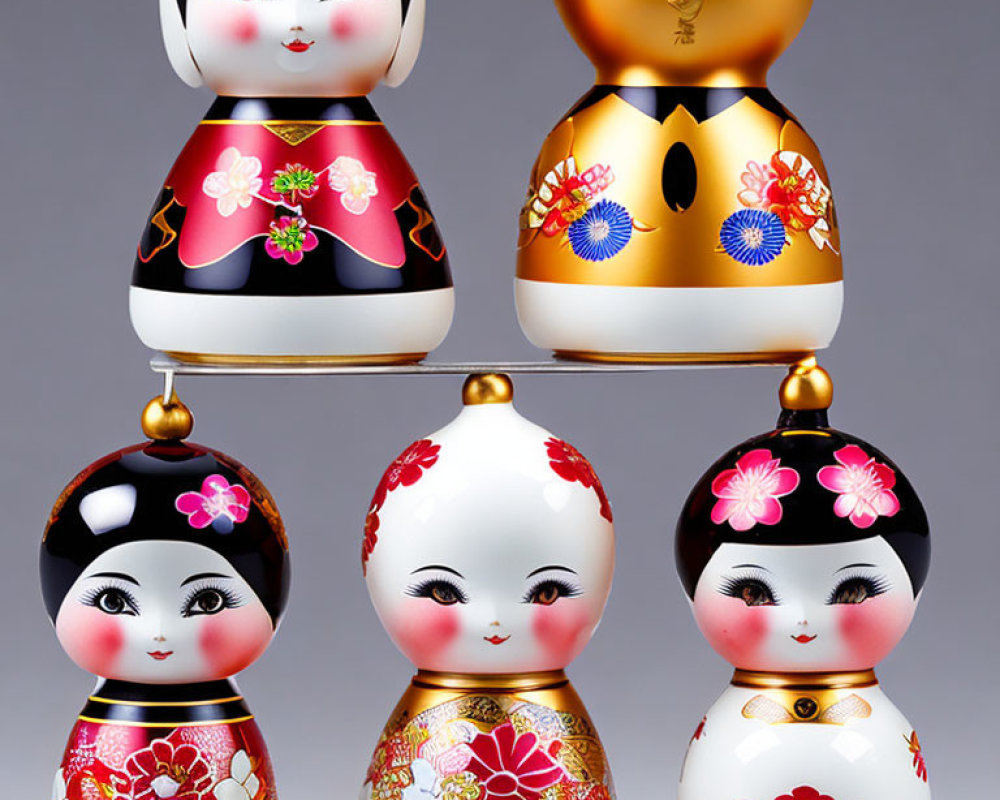Japanese Kokeshi Dolls with Floral Designs on Gray Background