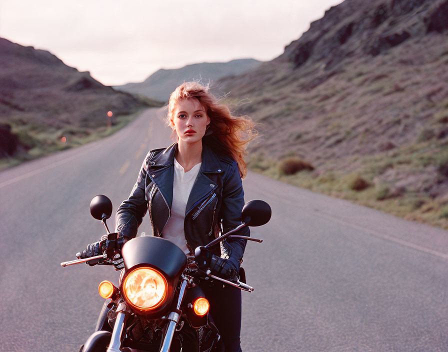 Red-haired woman on motorcycle at dusk with leather jacket