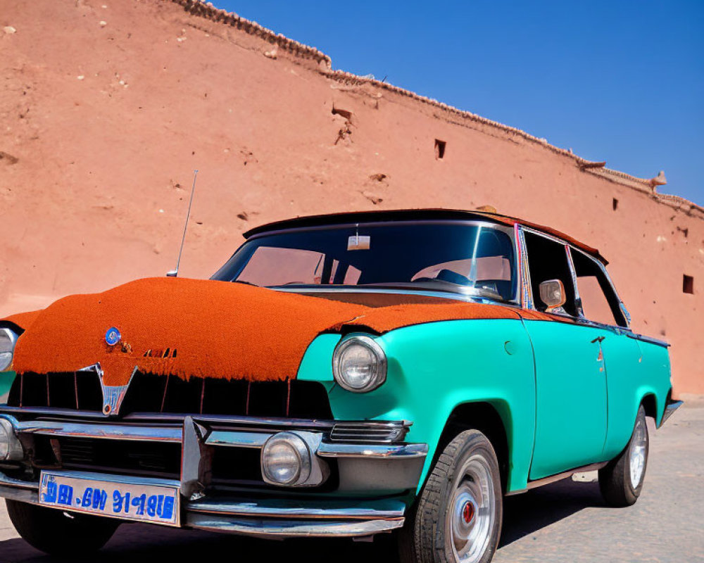 Vintage Turquoise Car with Red Fabric Cover Parked by Terracotta Wall