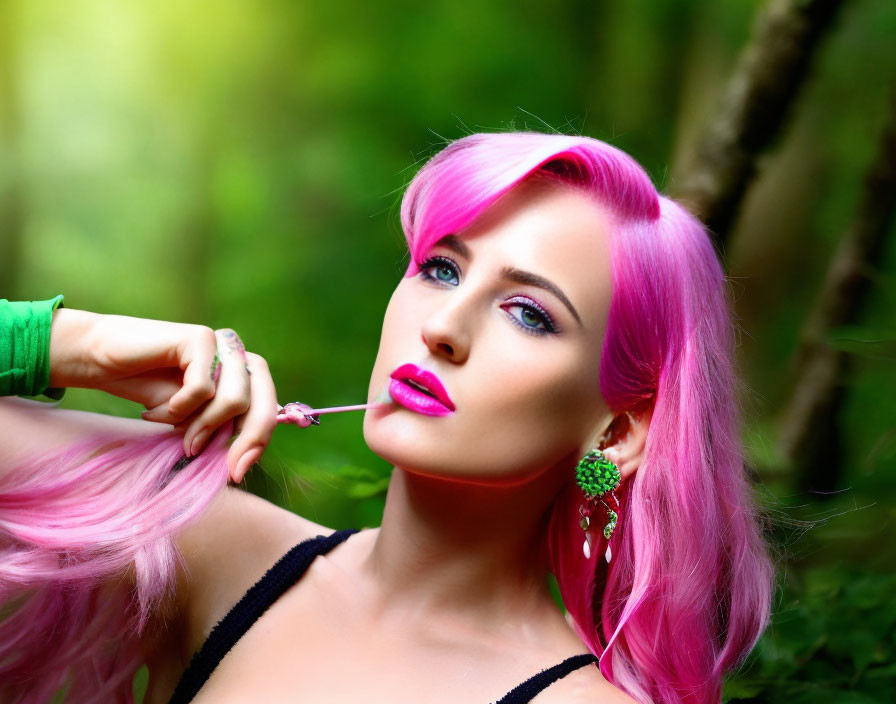 Vibrant pink-haired woman in black top, touching flower in lush green forest