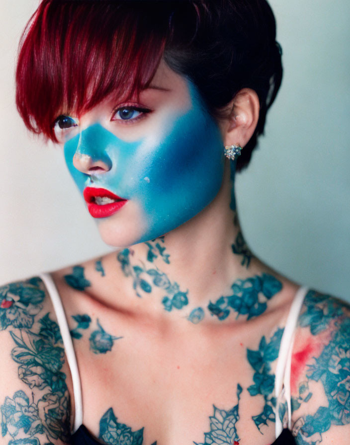 Blue-faced Woman with Red Hair and Floral Tattoos