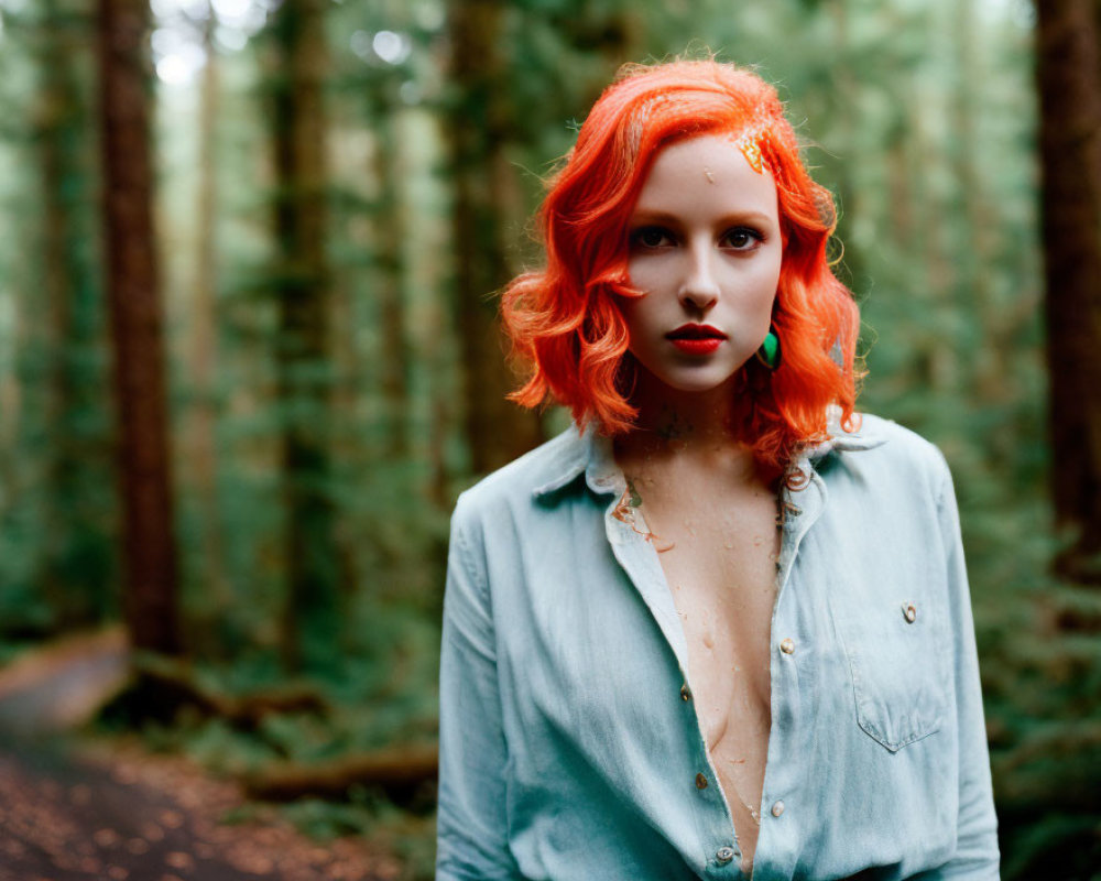 Woman with Bright Red Hair and Blue Shirt Standing in Forest