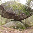Levitating moss-covered boulder in misty forest landscape