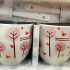Ornate cups with tree and bird designs on floral tray with metallic details