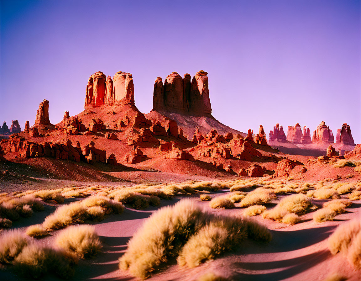 Sunset desert landscape with sandstone formations and purple sky