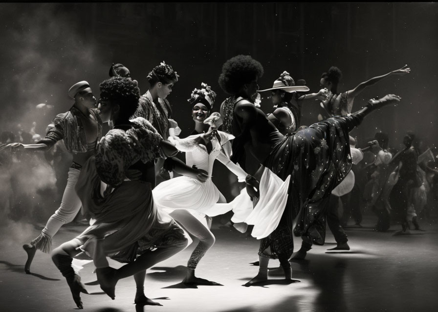 Monochrome image of dancers in motion on a stage with atmospheric lighting