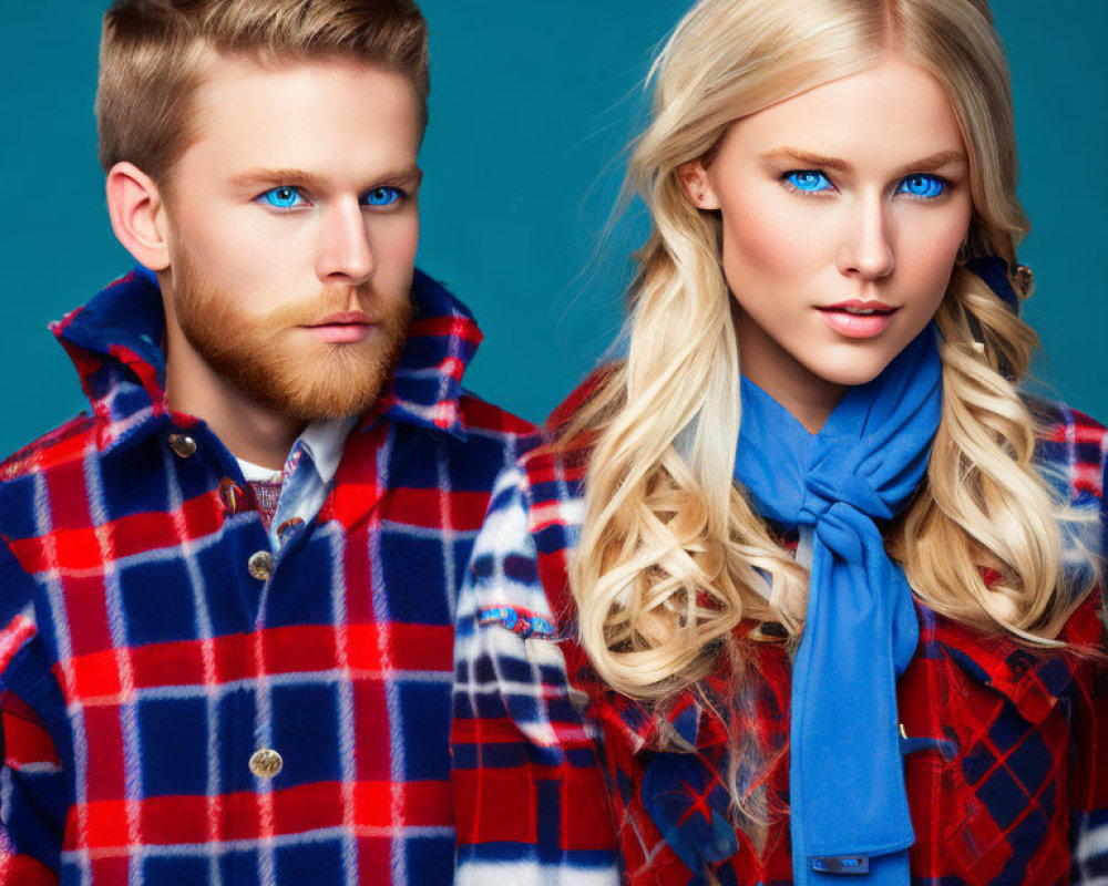 Man and woman with blue eyes in matching plaid coats on teal background.