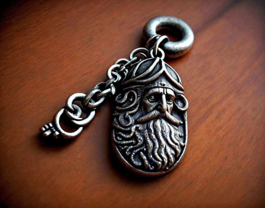 Detailed Bearded Face Carving Metal Keychain on Wood Surface