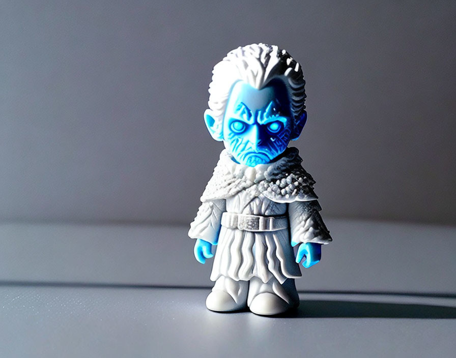 Fantasy character figurine with blue face markings and white outfit on grey backdrop